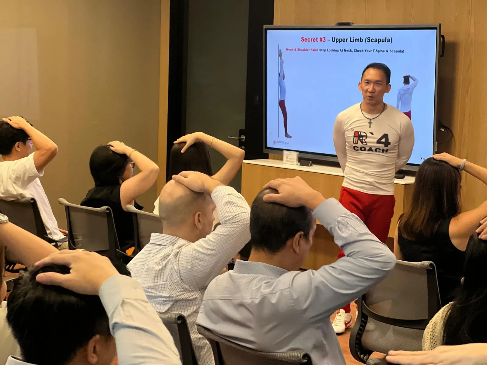 Nelson Chong leading a practical workplace wellbeing session for an office team